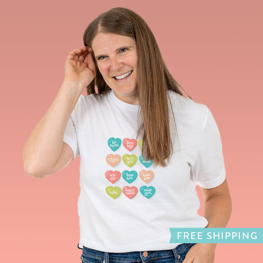 Women’s white Valentine’s Day T-shirt with colorful candy conversation hearts. Fun, nostalgic design—perfect to celebrate love or treat yourself.