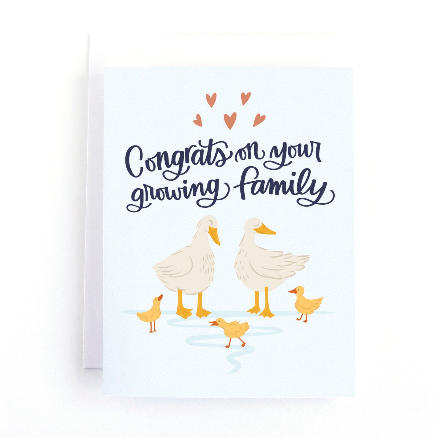 New baby card for parents of twins, triplets and quadruplets featuring a sweet illustration of a mother and father duck with their ducklings and the hand lettered greeting, congrats on your growing family.