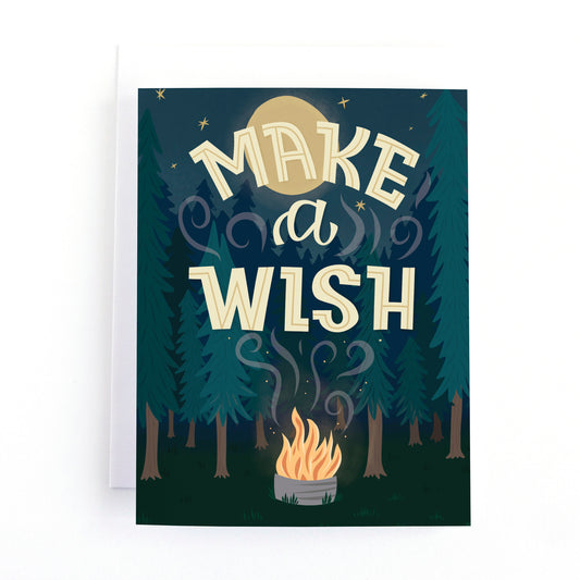 Camping themed birthday card with an illustration of a campfire in the woods under a sky full of stars and a full moon with the text, Make a Wish.