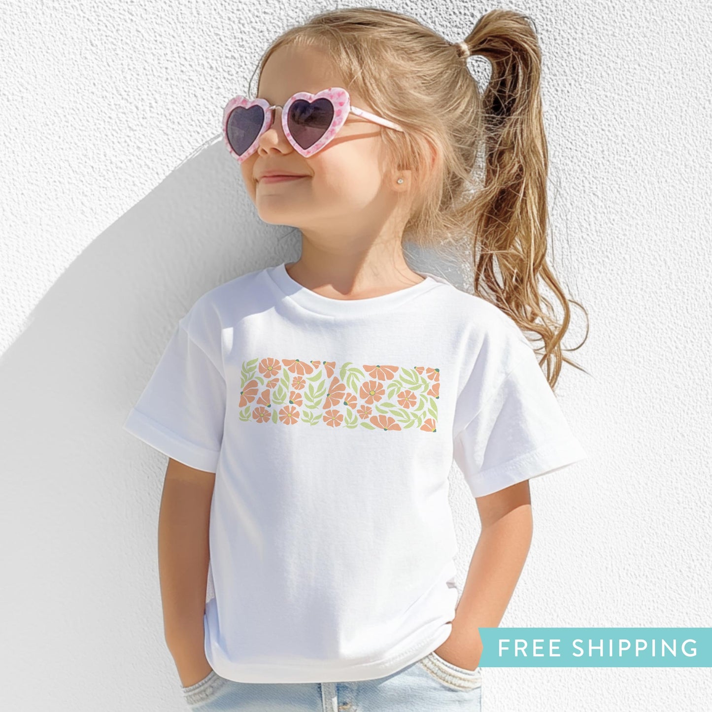 children's white t-shirt with pink flowers and green leaves.