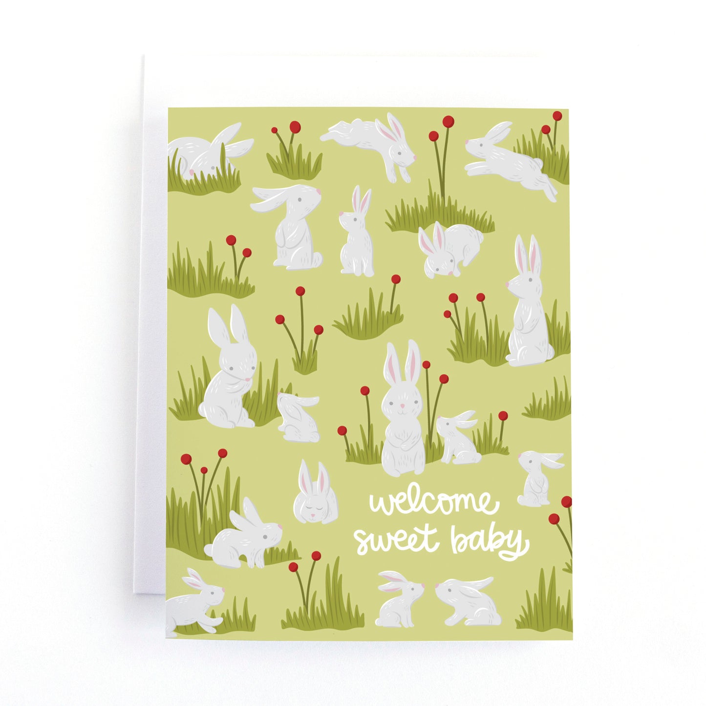 woodland themed baby shower card with bunnies in a meadow of flowers and the message, welcome sweet baby.