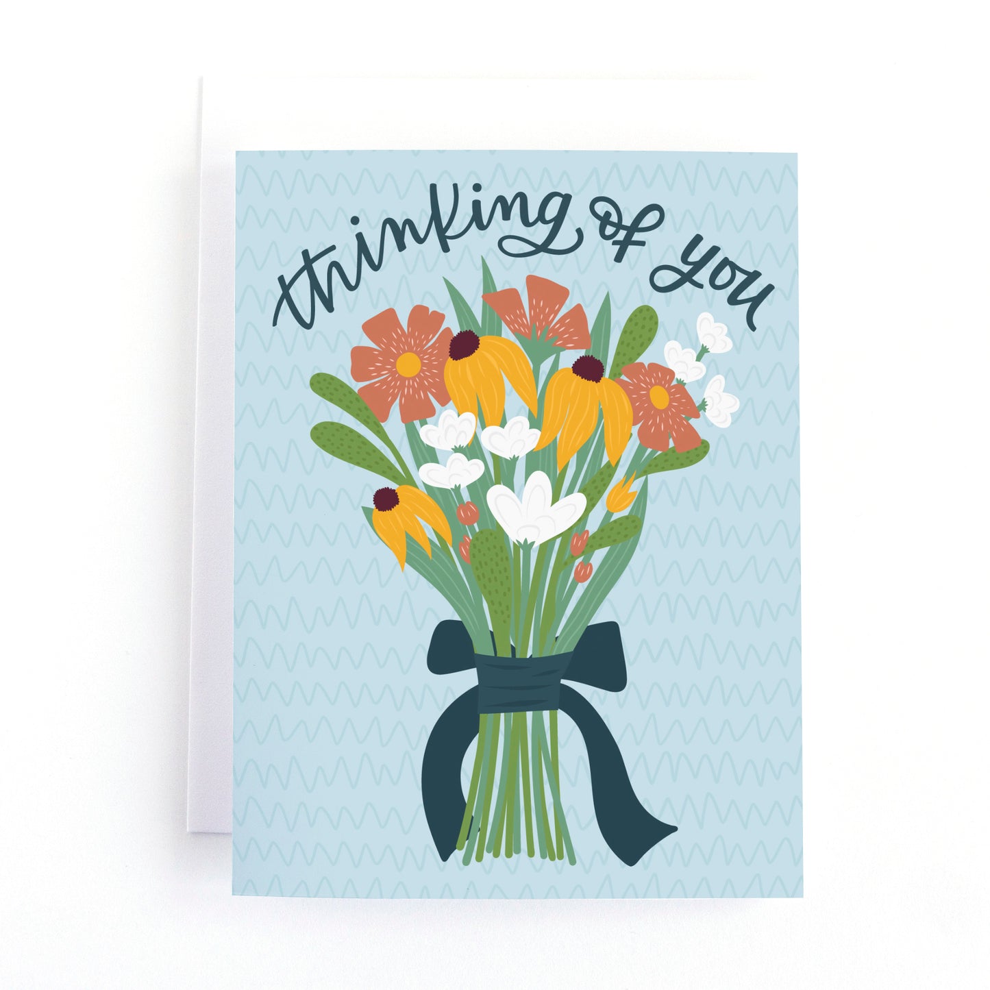 thinking of you card with a simple hand tied bouquet of flowers and the hand lettered text, thinking of you on a textured blue background.