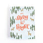 a christmas card featuring a snowy woodland scene and the greeting all is merry and bright.