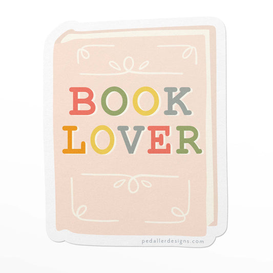 Book themed vinyl sticker with colourful text that says "book Lover" on an illustration of a book in light pink.