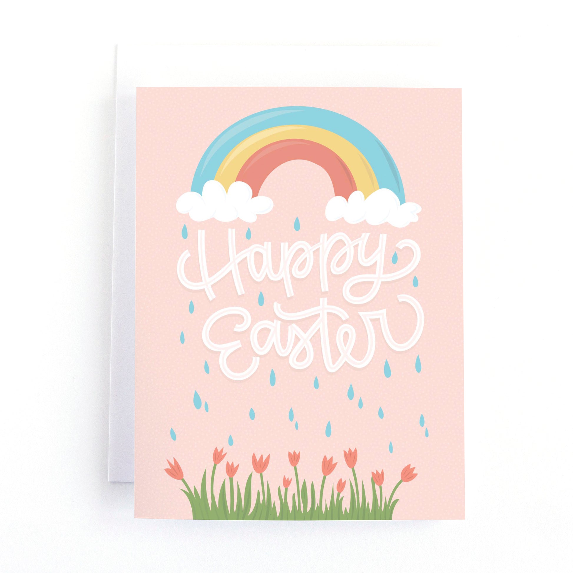 Easter card with a colourful rainbow and raindrops sprinkling on some spring tulips with the message, Happy Easter.