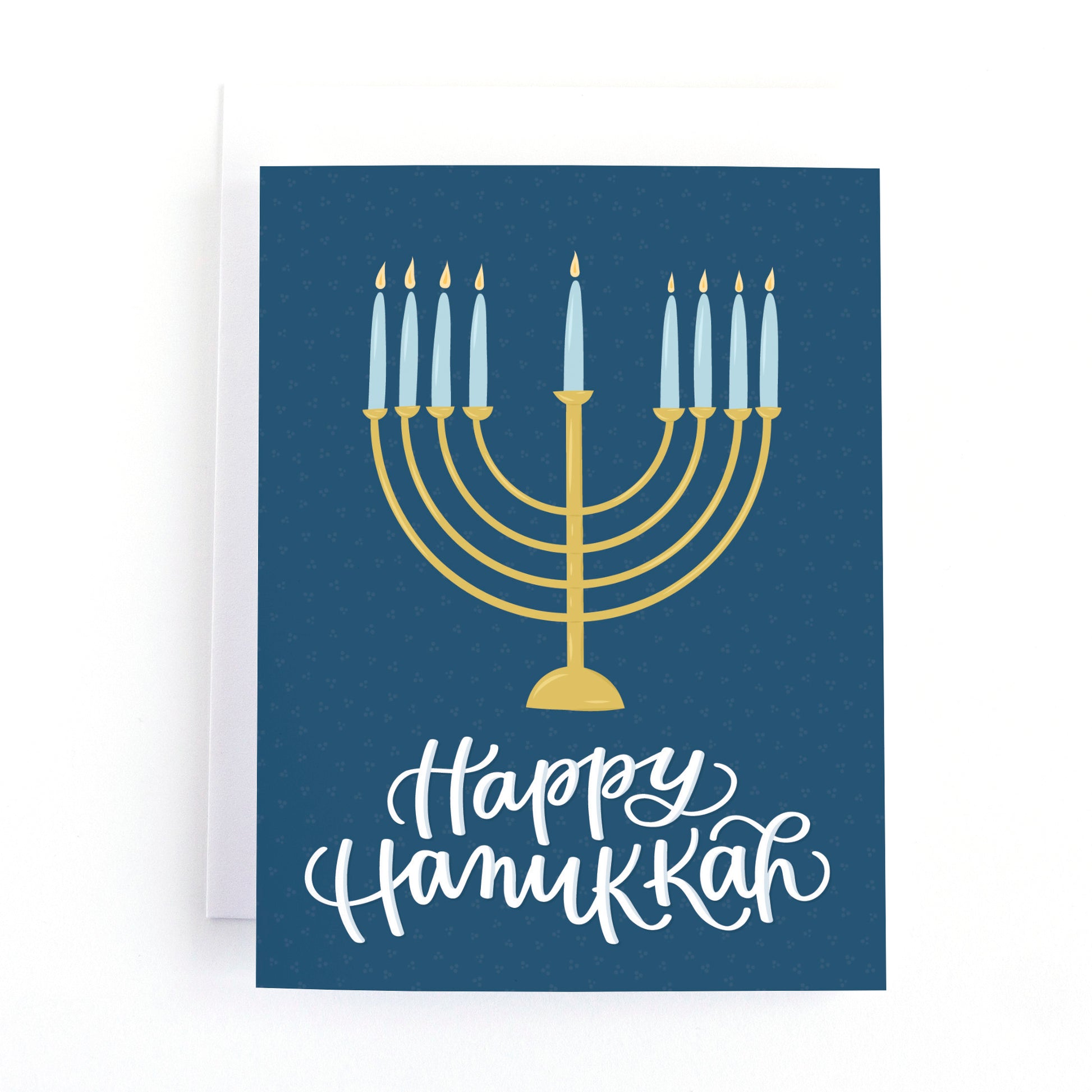 Hanukkah card with a modern gold menorah with lit candles and the hand lettered greeting Happy hanukkah