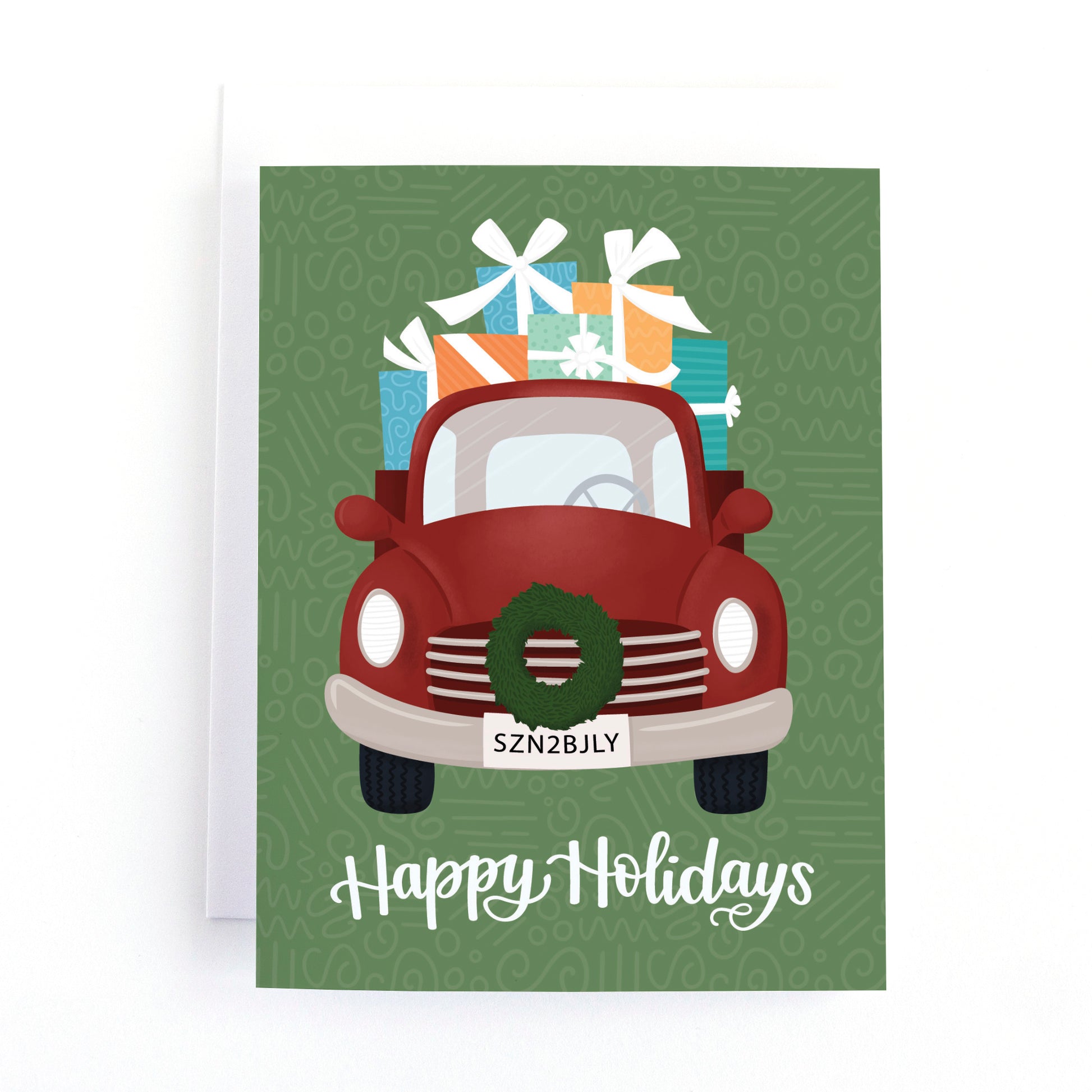 Christmas holiday card featuring a vintage red truck loaded up with gifts and the greeting, happy holidays