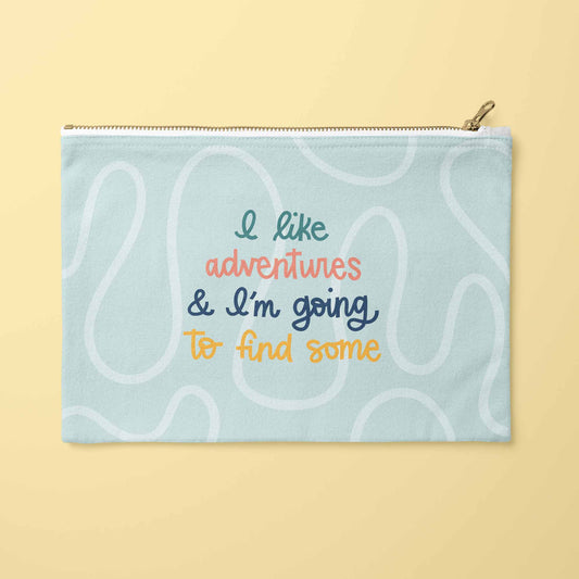 A light blue zippered pouch with a gold zipper and a gold pull tab, featuring a retro-style pattern of wavy white lines and colorful text that reads 'I like adventures & I'm going to find some'. 