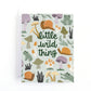 A new baby greeting card with a white envelope, featuring a whimsical forest pattern of snails, mushrooms, and a frog with the text 'little wild thing' in dark green script.