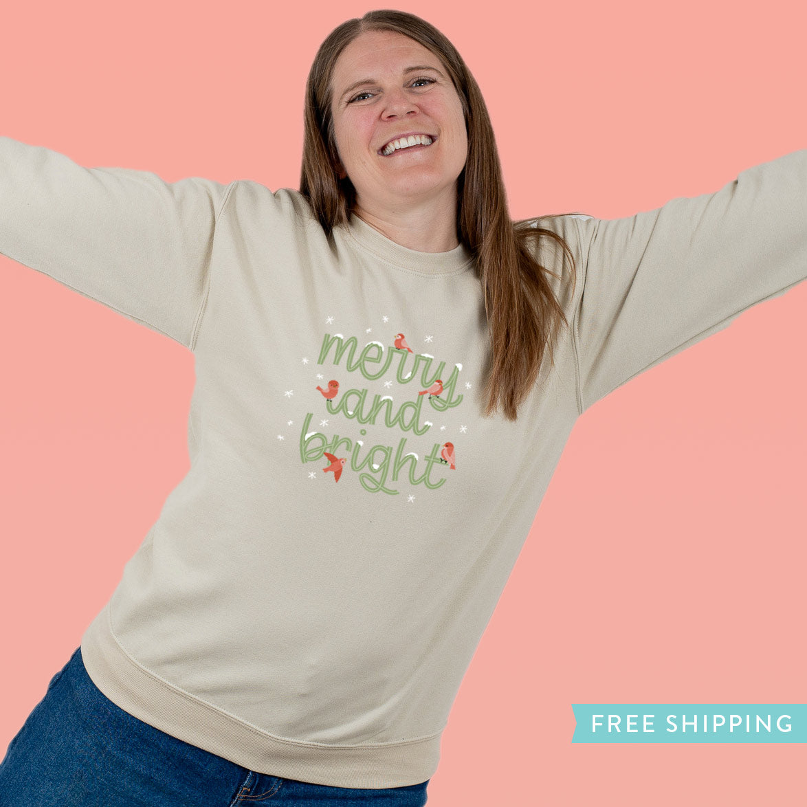 Person wearing a beige sweatshirt with 'merry and bright' text on a snowy background surrounded by red birds.
