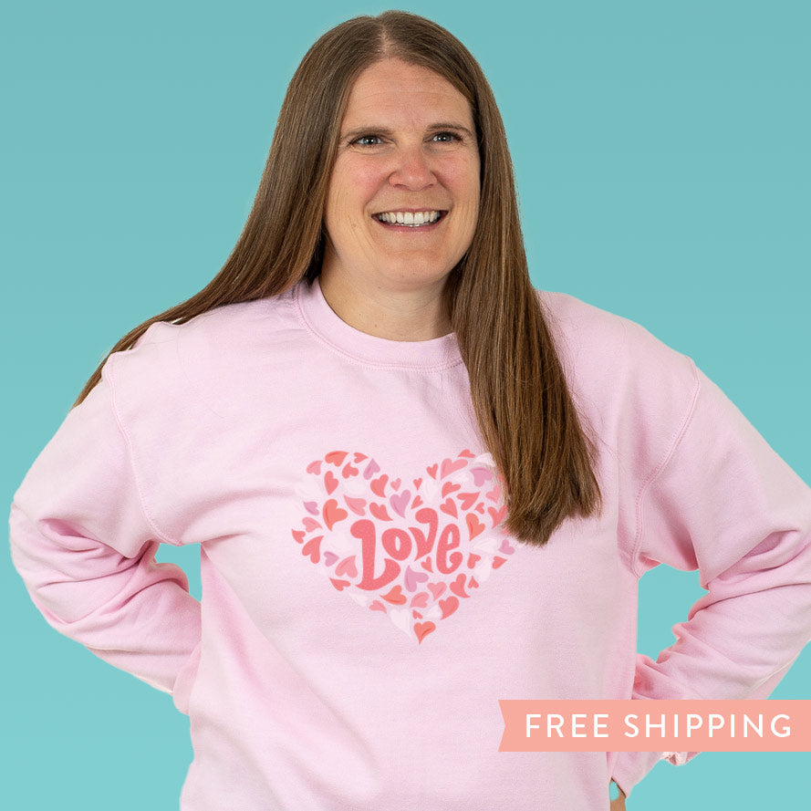 Women’s pink Valentine’s sweatshirt with playful white and pink heart design. Cozy, fun style perfect for Valentine’s Day, gifting, or treating yourself.
