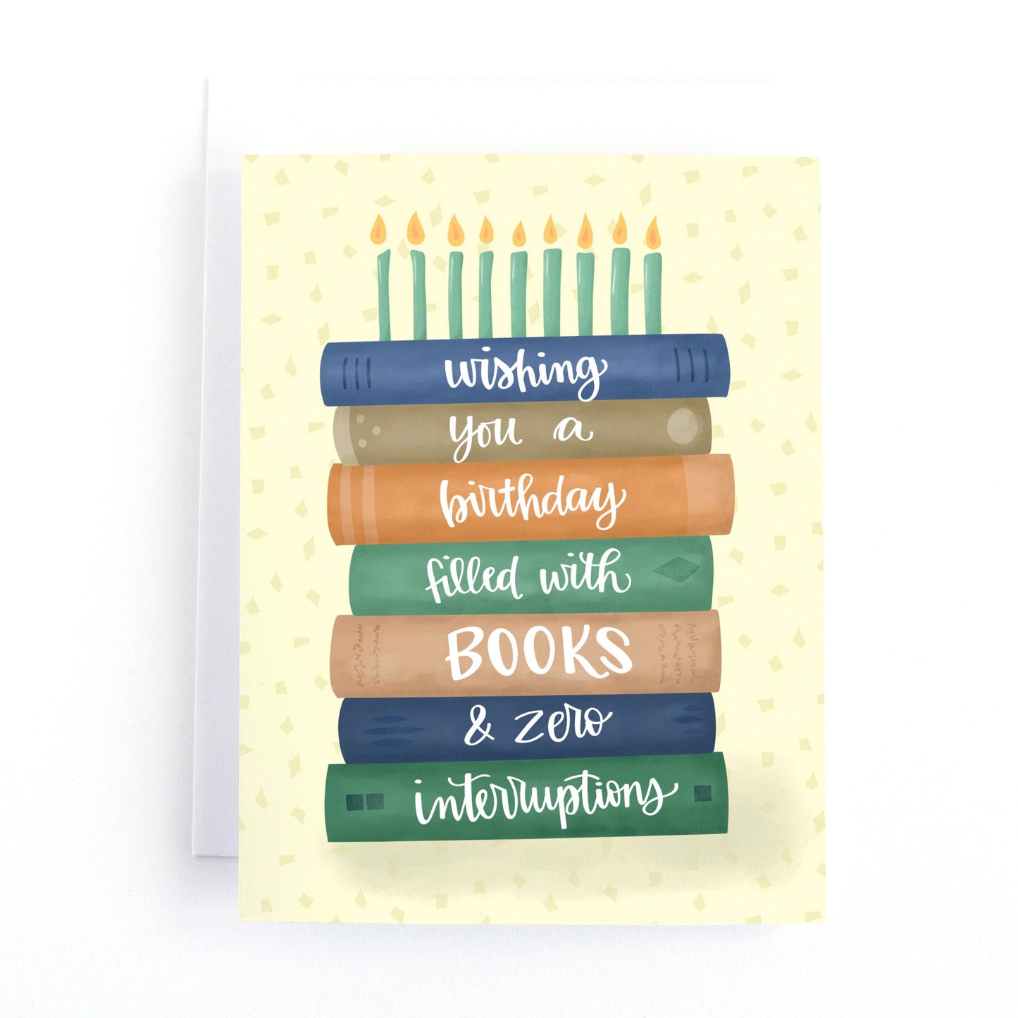 Book themed birthday card with a colourful stack of books with candles on top resembling a birthday cake. features the hand lettered greeting, "wishing you a birthday filled with books and zero interruptions."