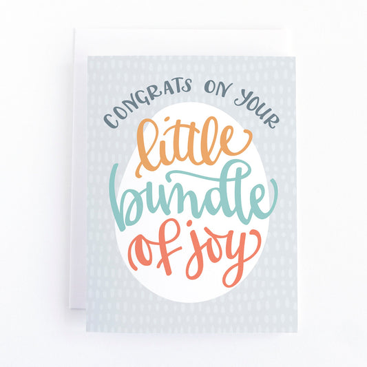 gender neutral new baby card featuring the message, congrats on your little bundle of joy in multi-coloured lettering on a gray background.