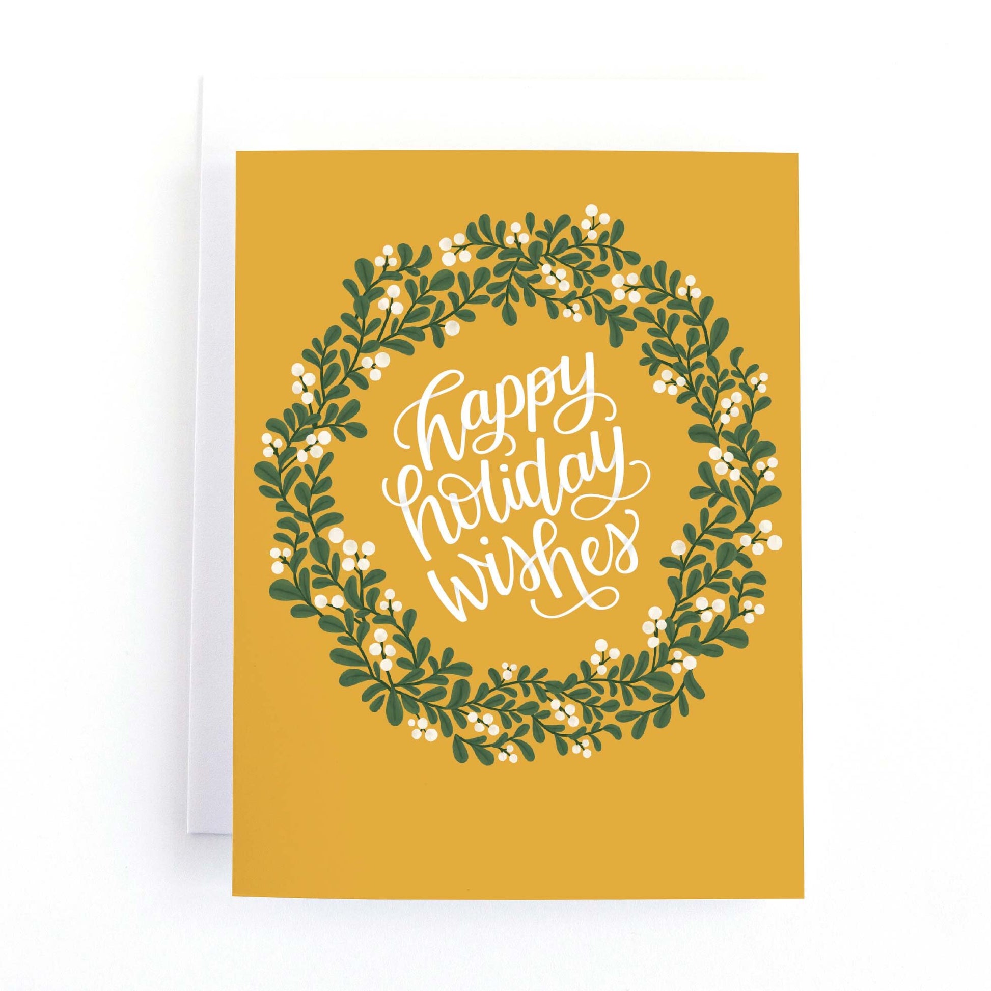 Yellow holiday card with and christmas wreath of mistletoe greenery and berries and the hand lettered message happy holiday wishes