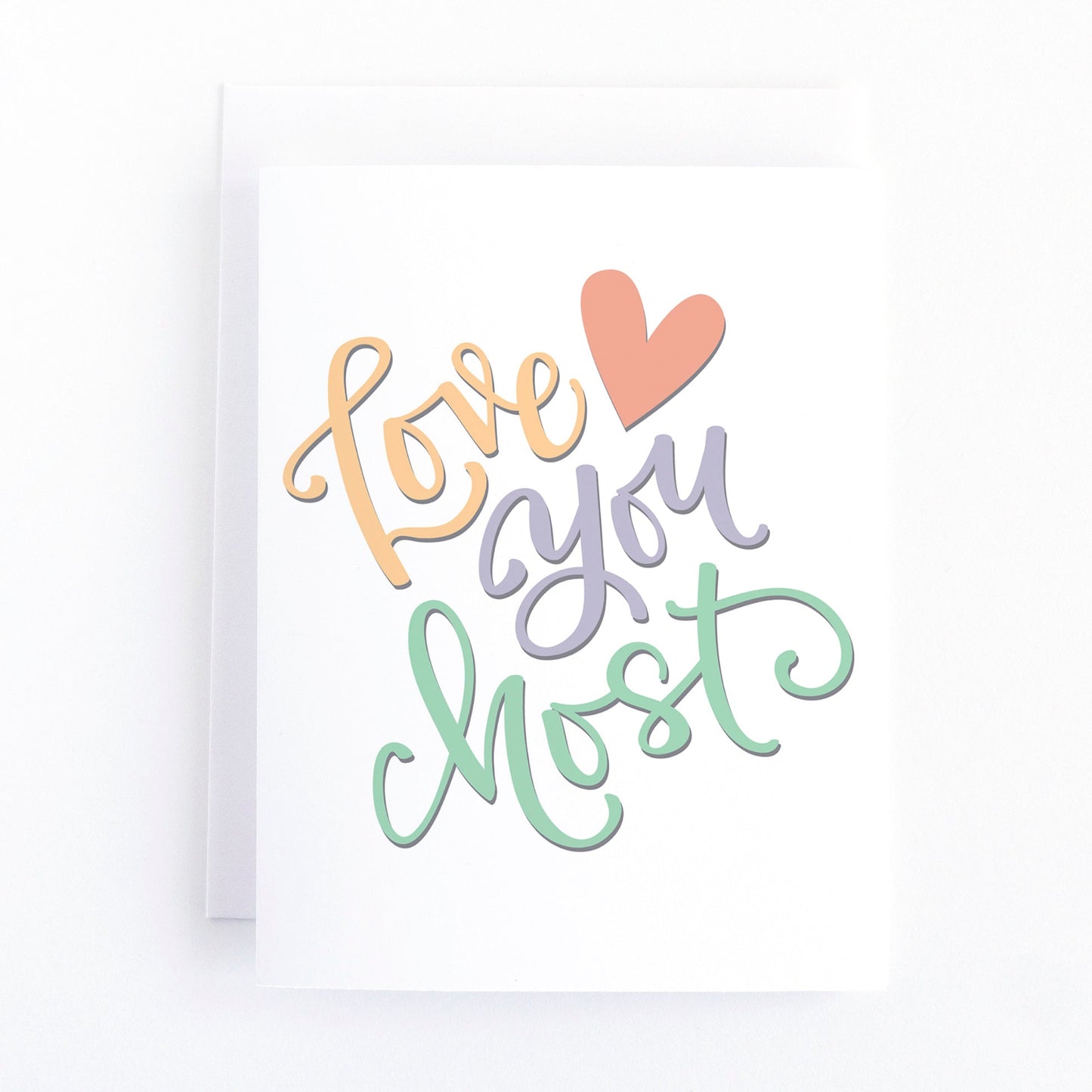 Simple valentine's day card with the hand lettered greeting, love you most in a soft rainbow of colours