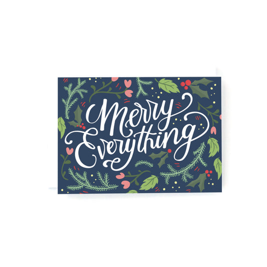 mini christmas card with white hand lettering that says Merry Everything surrounded by flowers and greenery on a navy background.