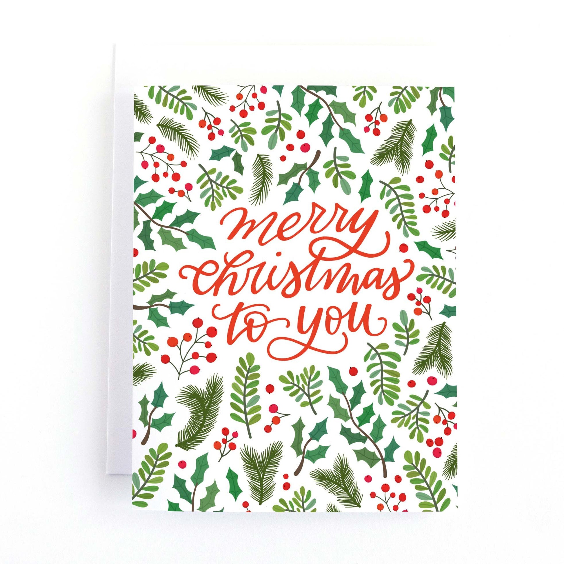 Christmas holiday greeting card with greenery, holly and berries and a hand lettered greenery