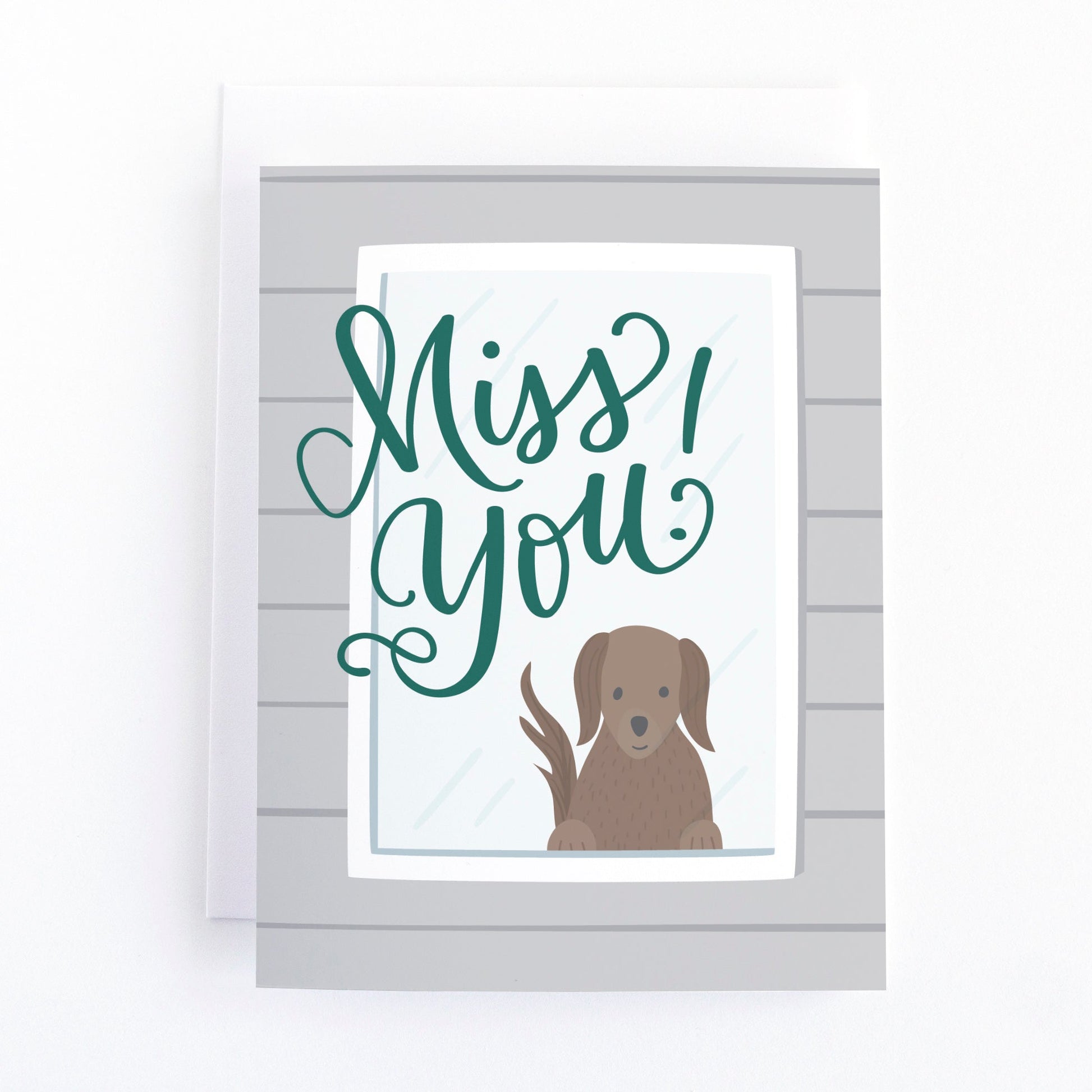 Miss you greeting card with a dog looking out the window and the hand lettered text, Miss you!