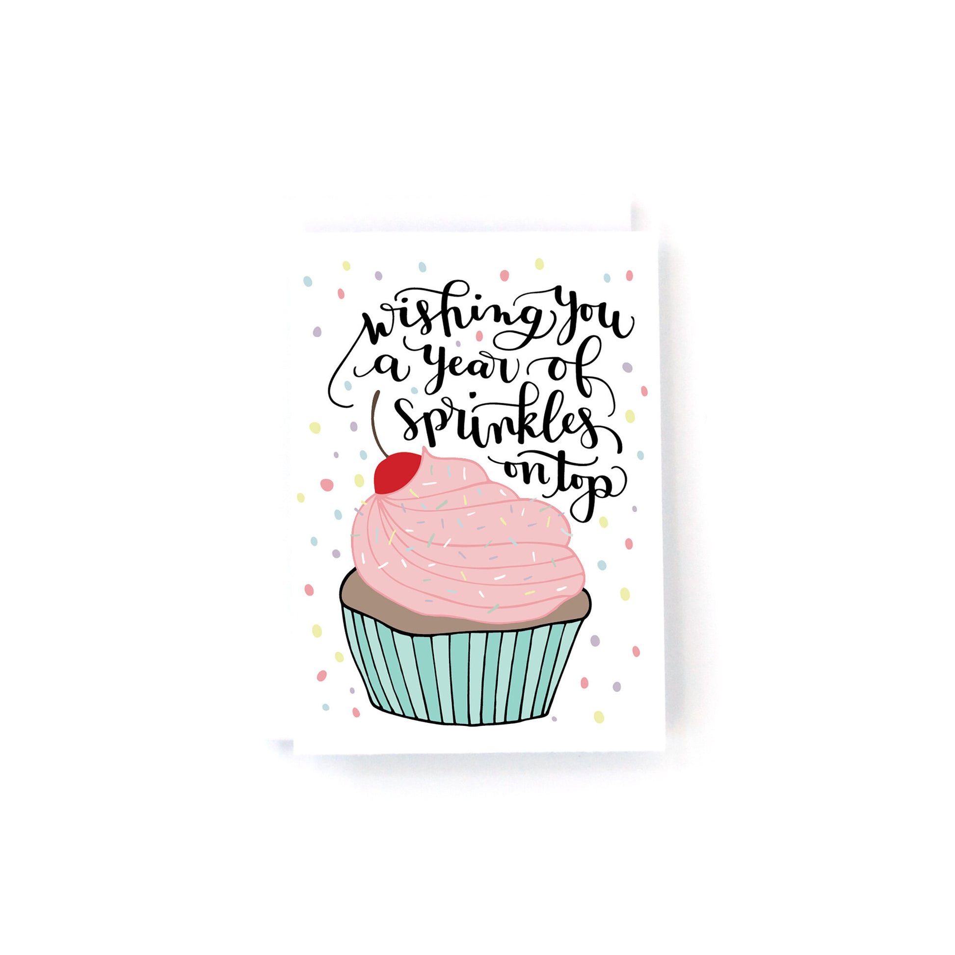mini birthday card with a pink and blue cupcake surrounded by confetti with the text, wishing you a year of sprinkles on top.