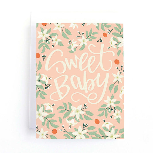Baby shower card featuring the hand lettering greeting, "Sweet Baby" on a pink background with white orange blossoms.