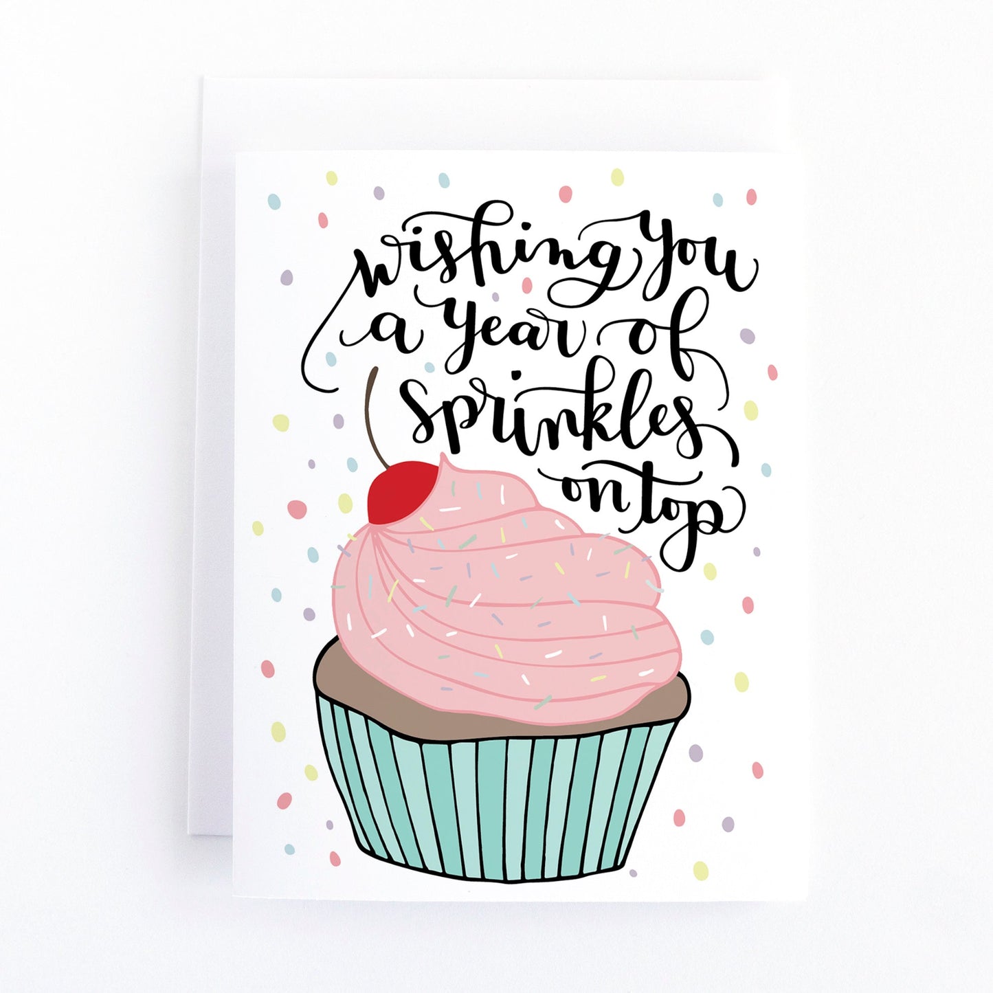 Birthday card with pink and blue cupcake that has sprinkles and cherry on top and a message that says wishing you a year of sprinkles on top.