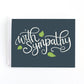 Sympathy card with white hand lettered text, With sympathy, surrounded by green leaves on a navy background.