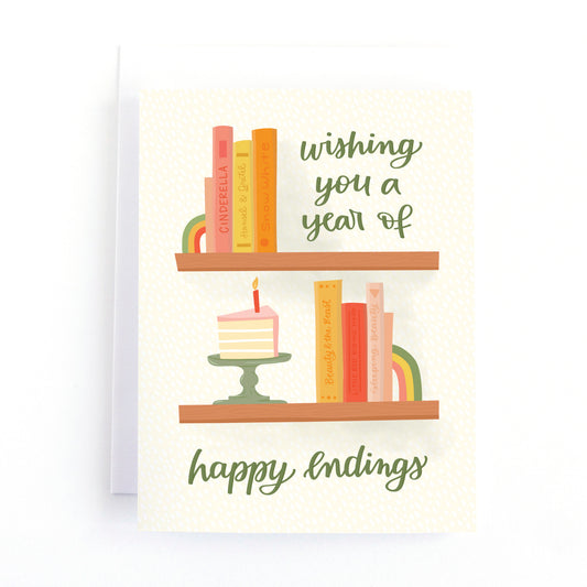birthday card with a shelf full of books and a slice of birthday cake and the message, wishing you a year of happy endings