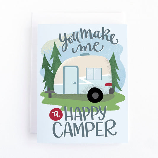 Valentines day card with an illustration of a retro camping trailer and the hand lettered text, you make me a happy camper